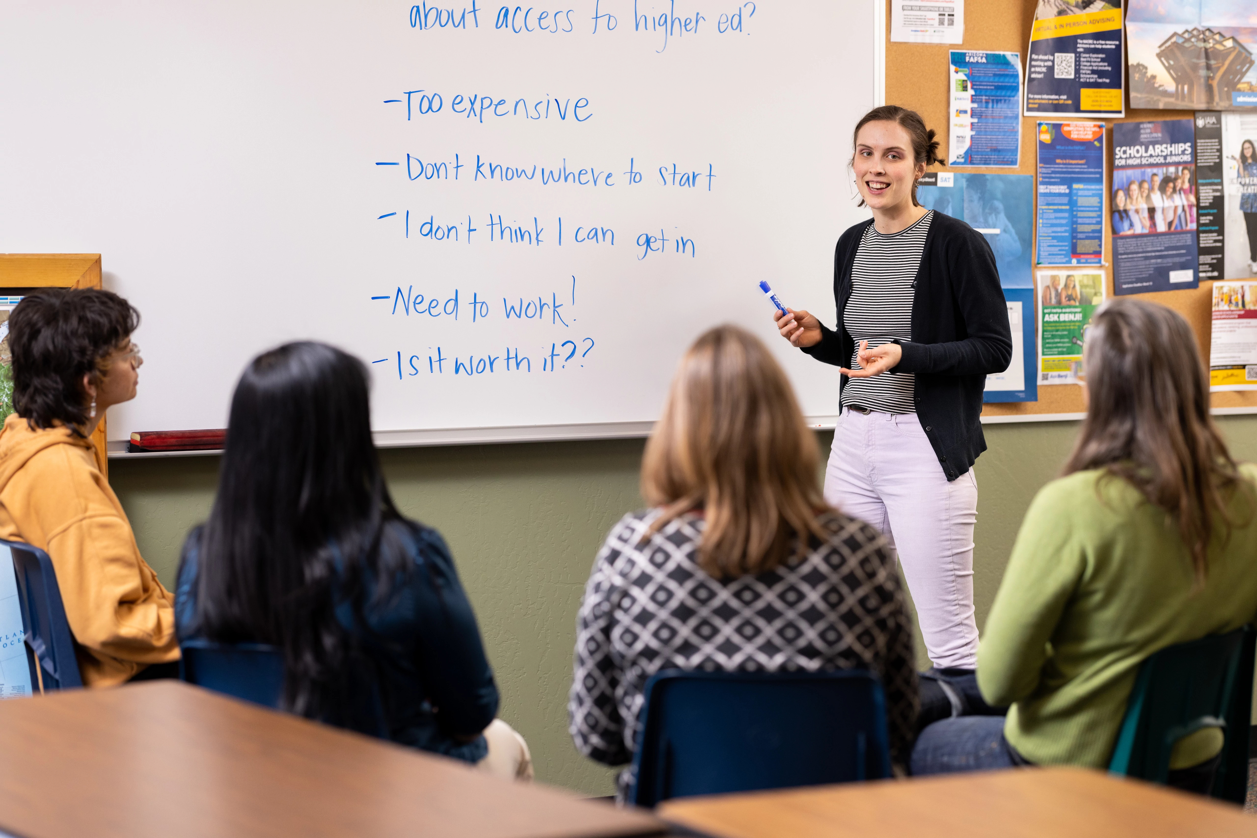 Instructor is standing at the front of a classroom teaching.