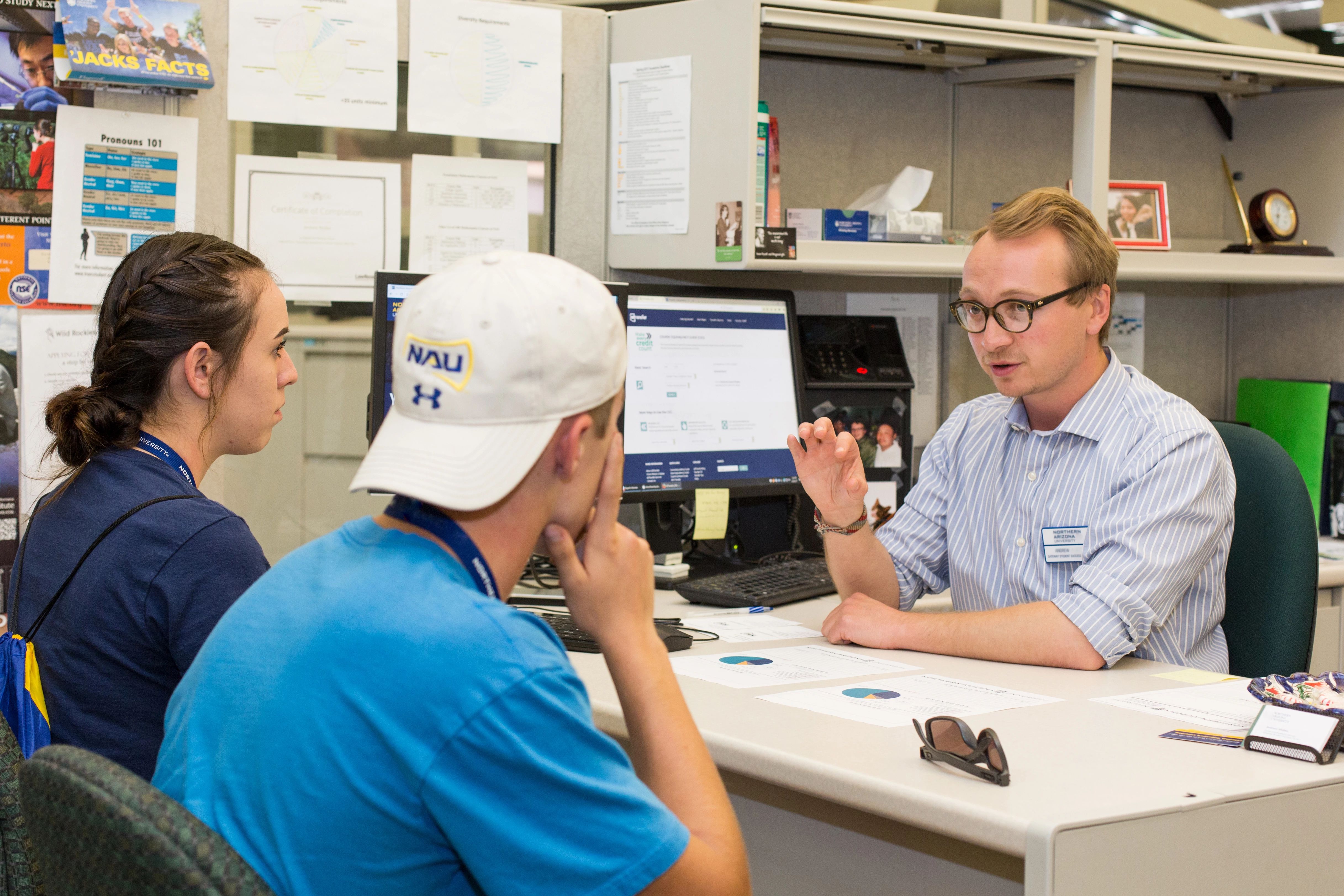 Two students talking to a staff member.