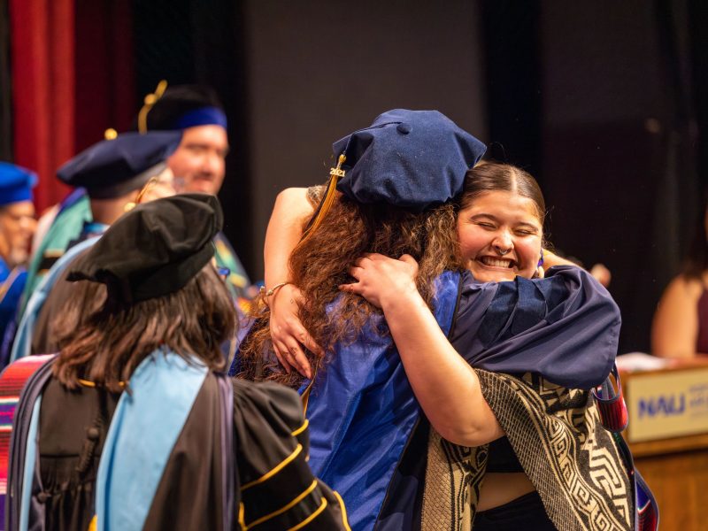 Convocation student hugging a professor.