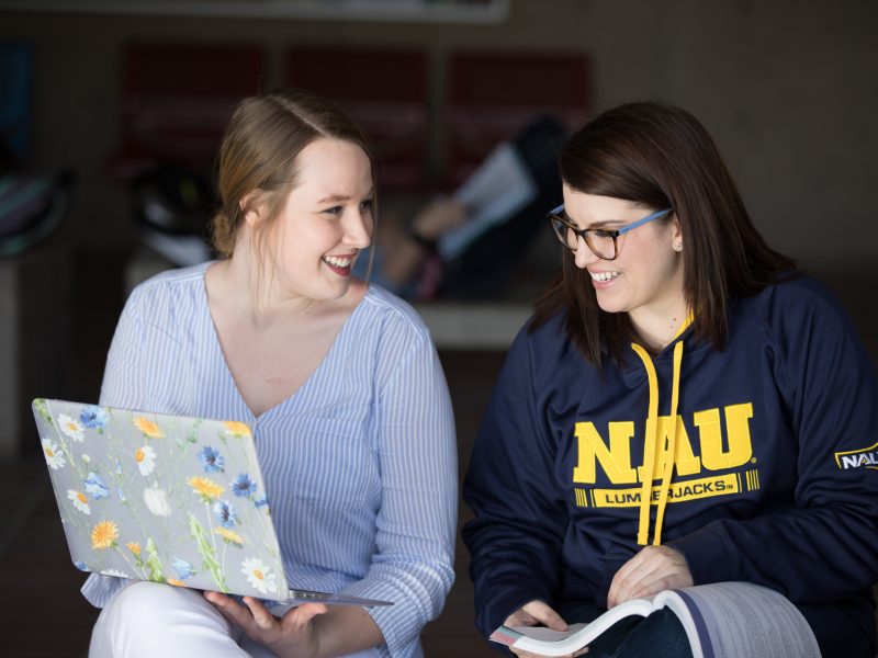 A photo of students smiling while sharing notes during study date.