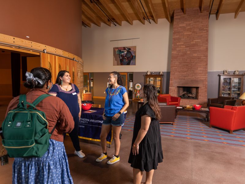 A photo of students standing in a circle and talking.