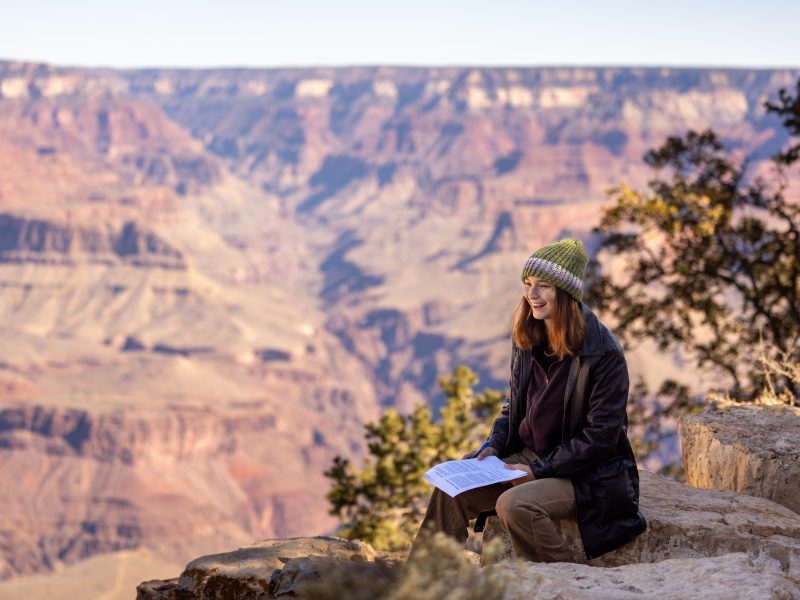 A photo of a student sitting at the Grand Canyon.