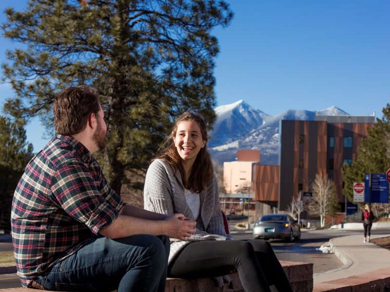 A photo of students sitting outside on the N A U campus.