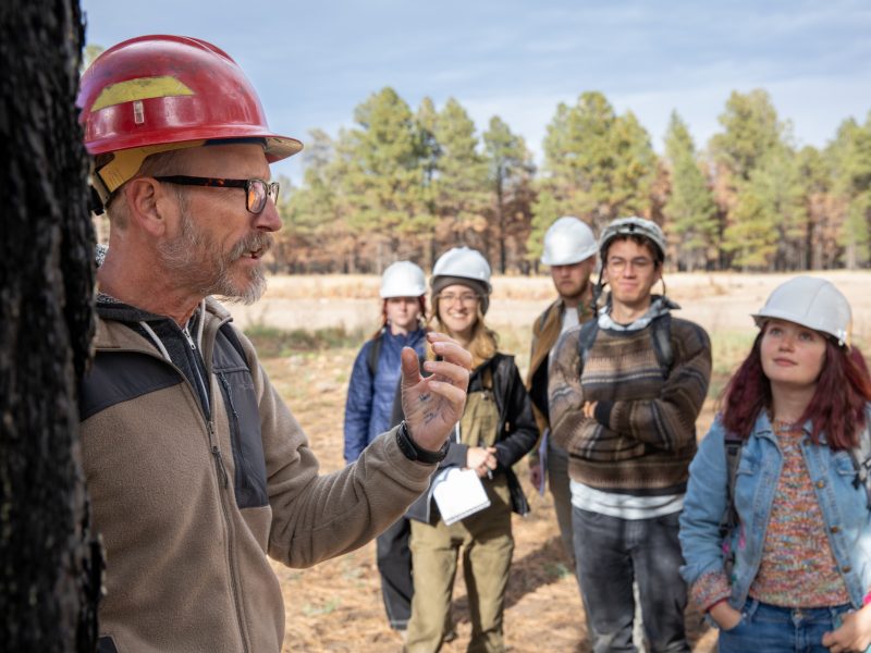 A photo of a professor and students talking outside.