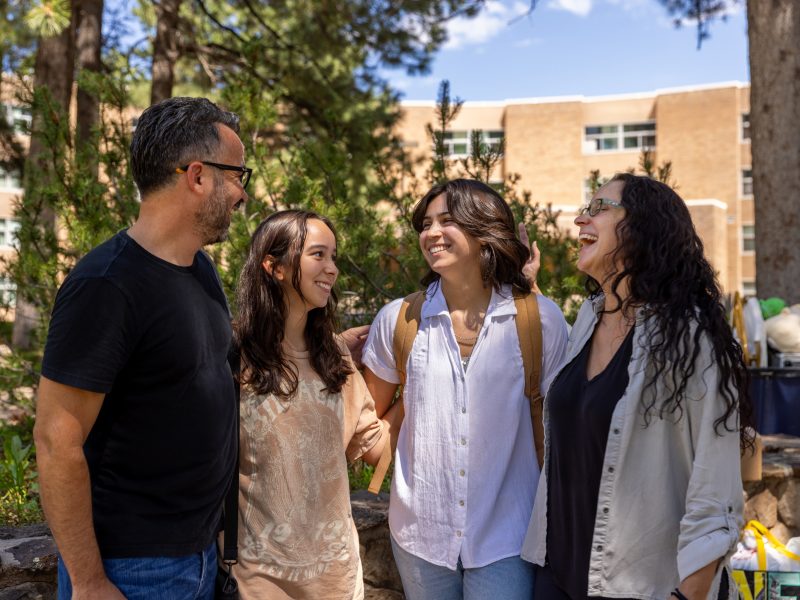 A new student standing with family on campus.