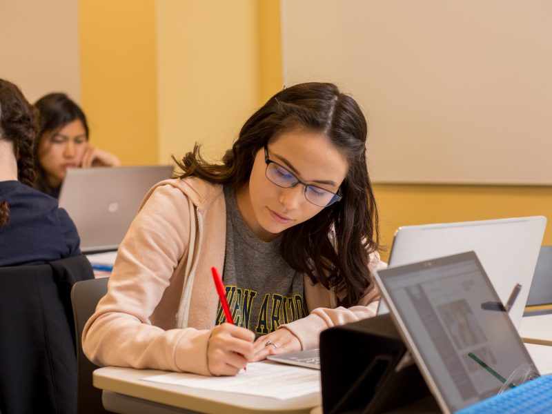 A student writing on a piece of paper.