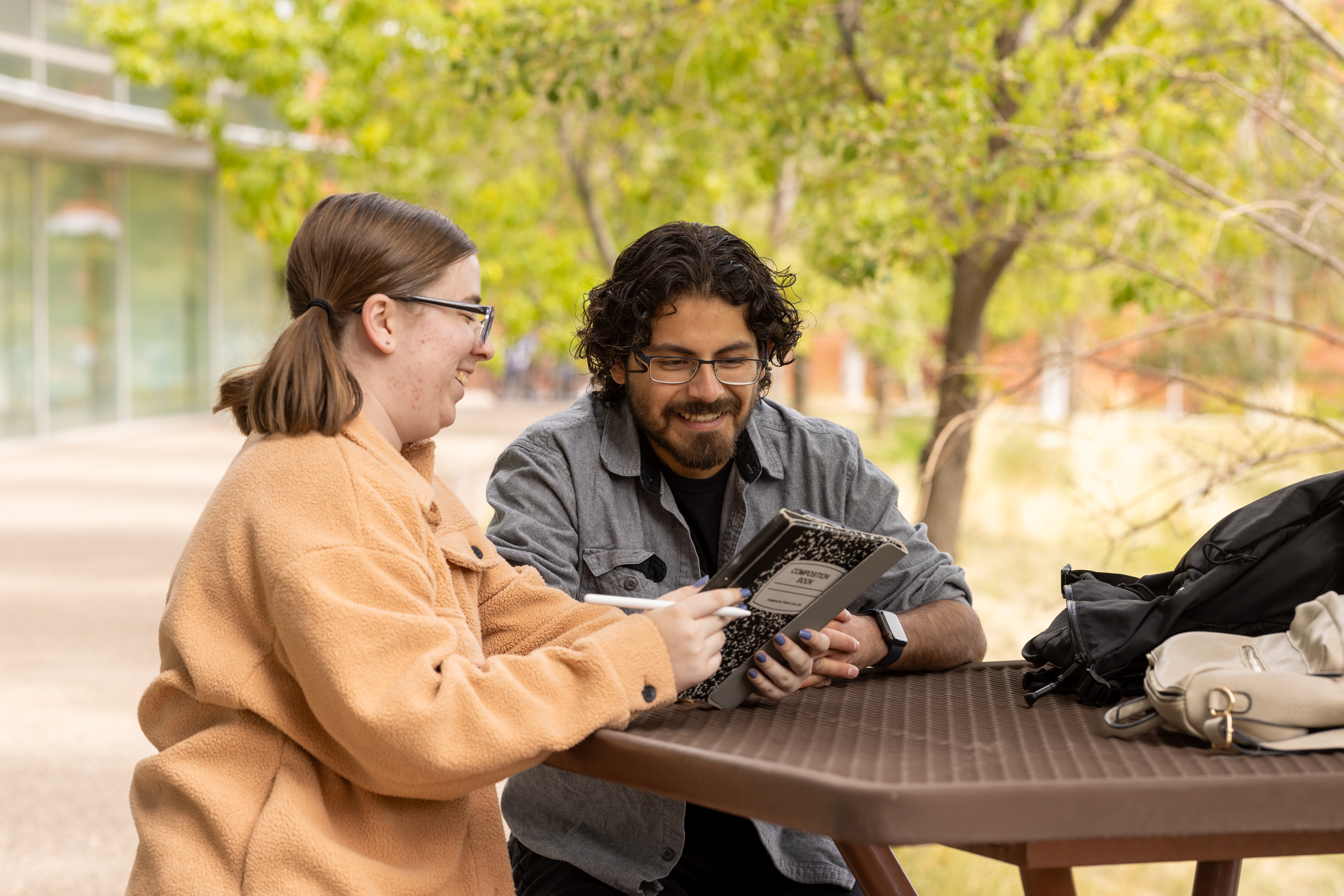 Students reading a journal together outdoors.