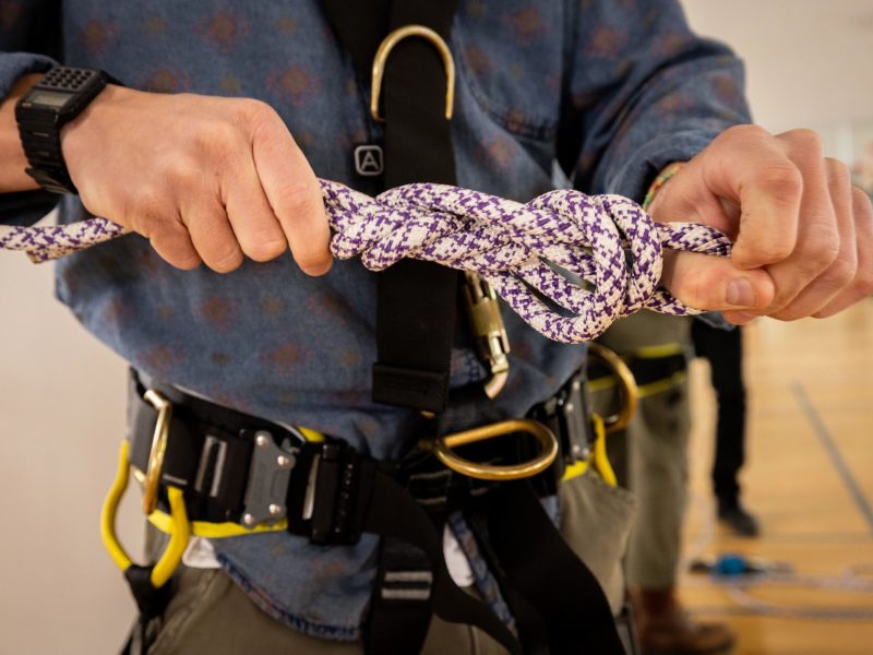 N A U student tying a knot in climbing rope..