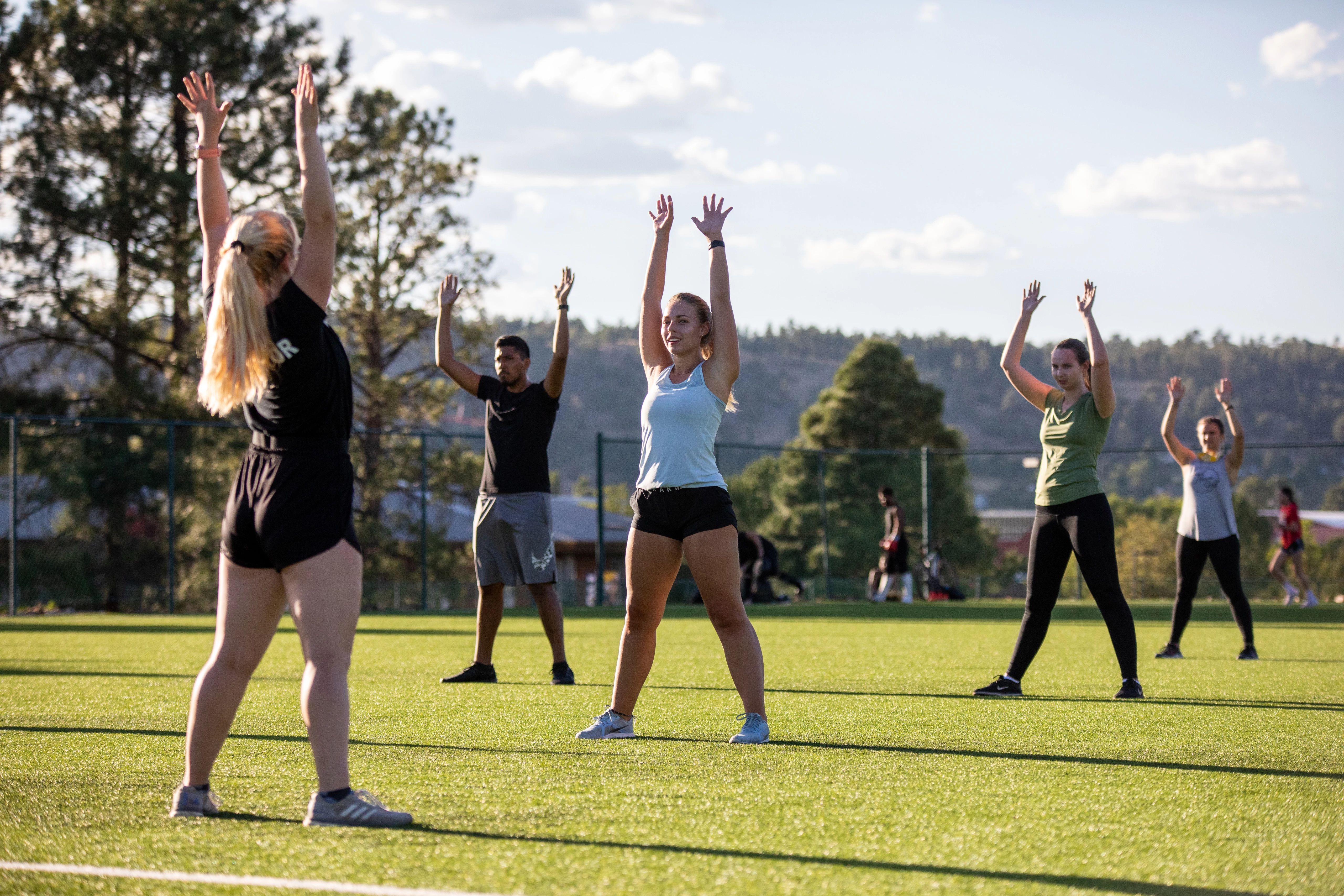 N A U students working out in a group fitness class outside.