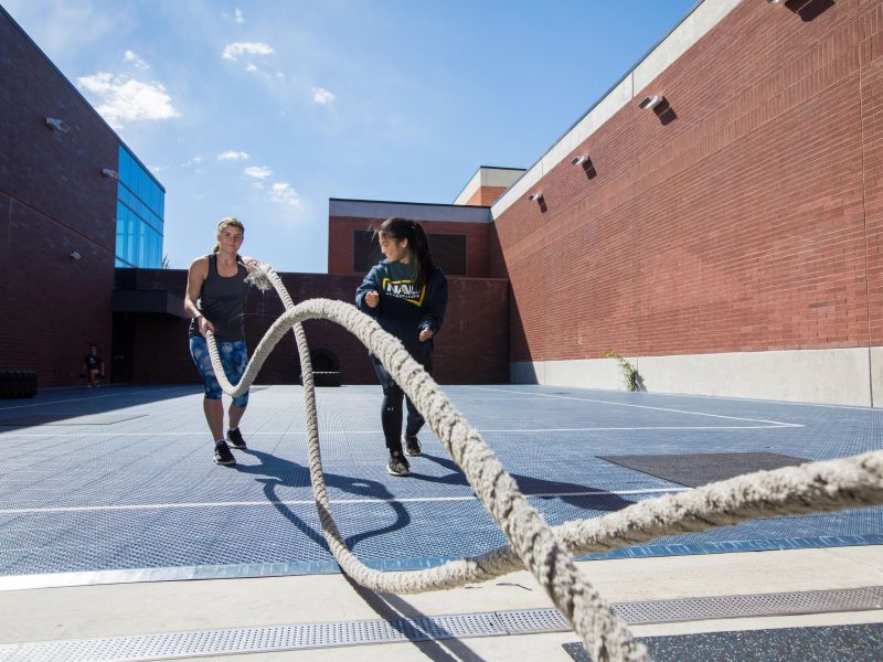 Student and a trainer using rope to workout.