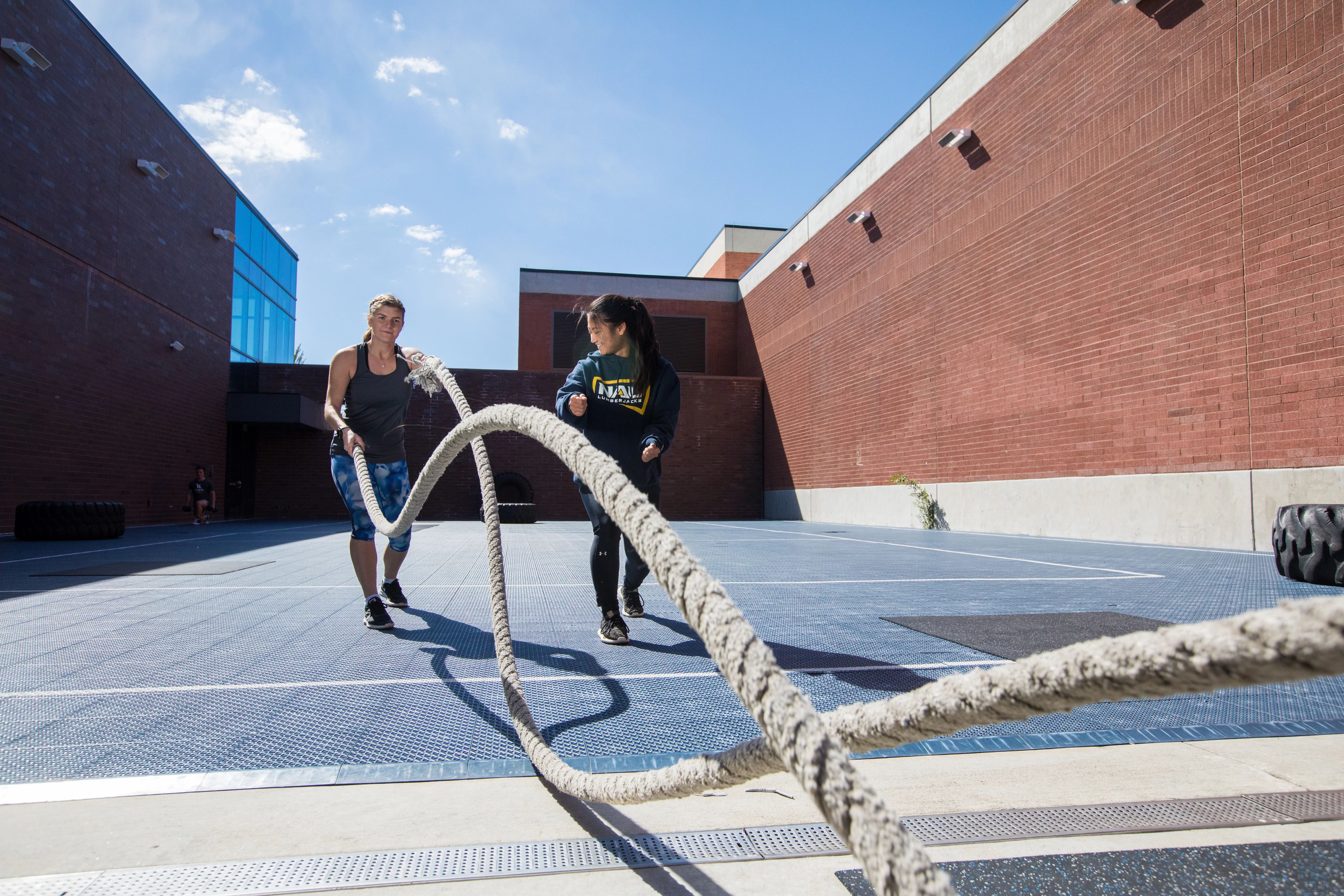 Student and a trainer using rope to workout.