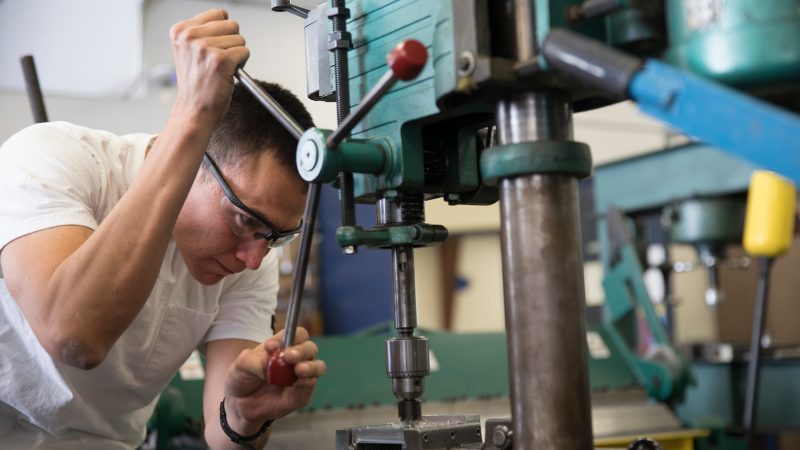 N A U student Jonathan Witherspoon working with machinery.