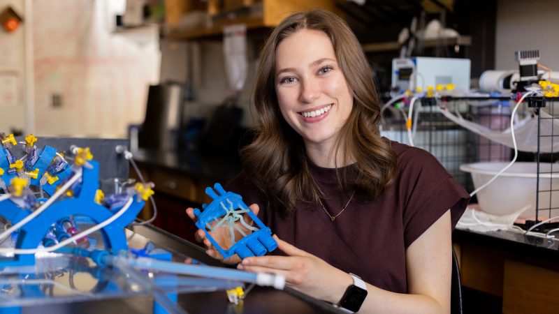 Olivia Fisher smiling and posing next to her creation.