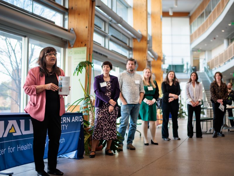 A professor addresses the group from a podium to present certificates to the graduates.