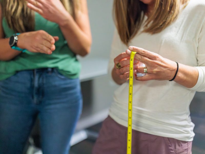 Project researchers look over the waist measuring device.