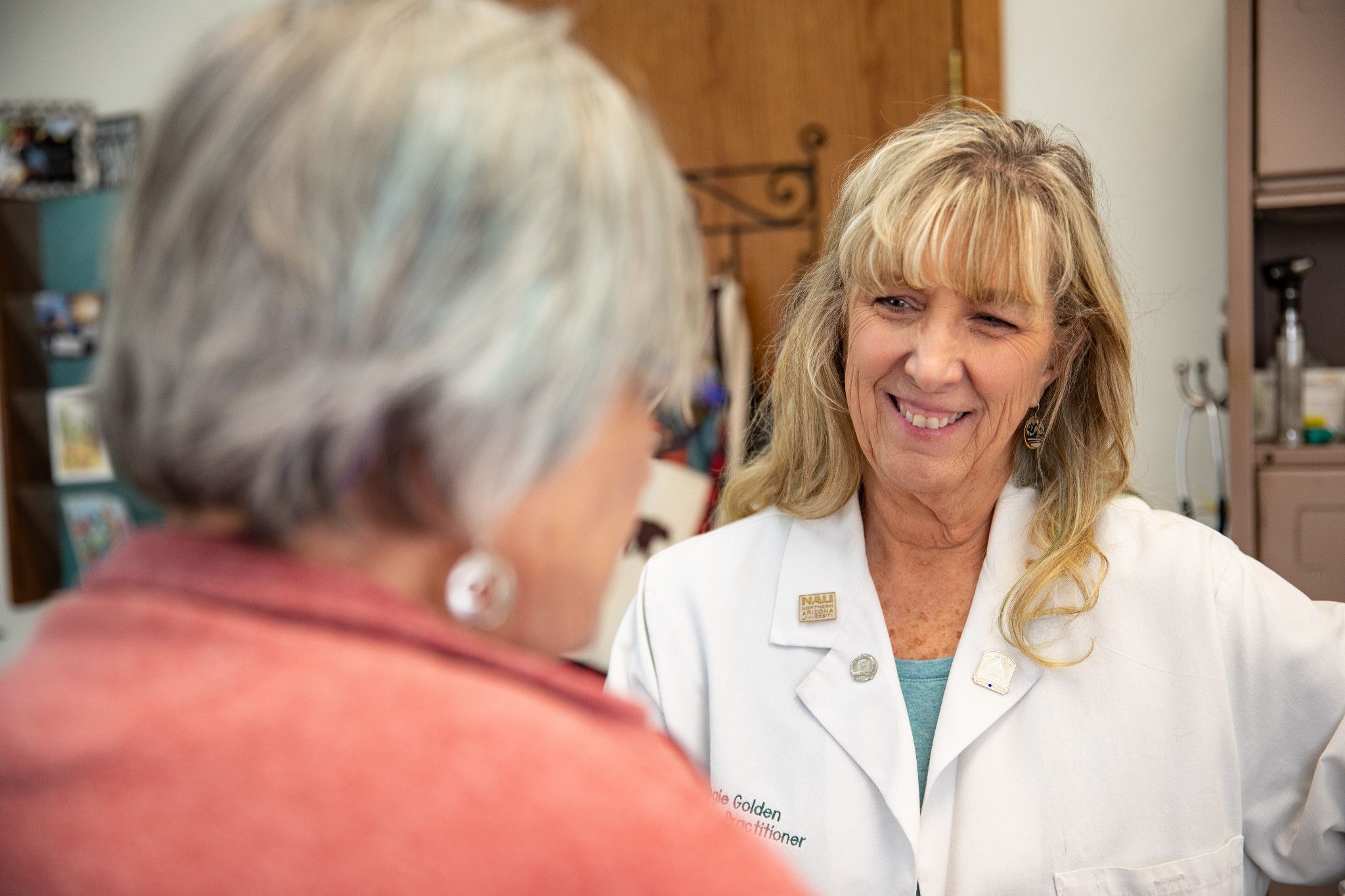 Nursing faculty member talking to another person while smiling.