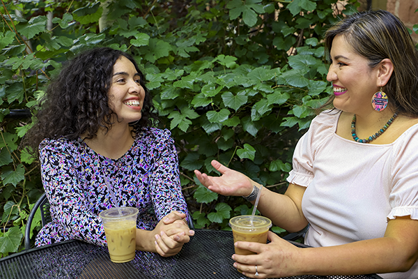 Alexandra Samarron and Carmenlita Chief sitting at a table talking.