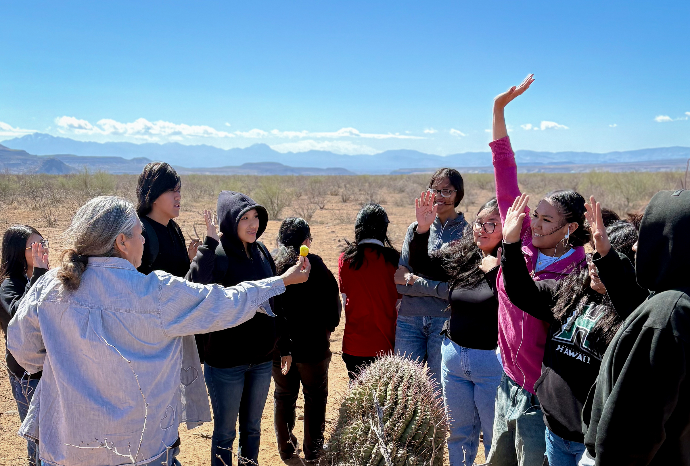 Twila Cassadore hands barrel cactus fruit to an eager student.