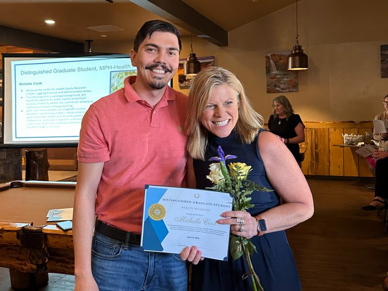 Michelle Cook receiving a Distinguished Graduate Student award, standing next to a man.