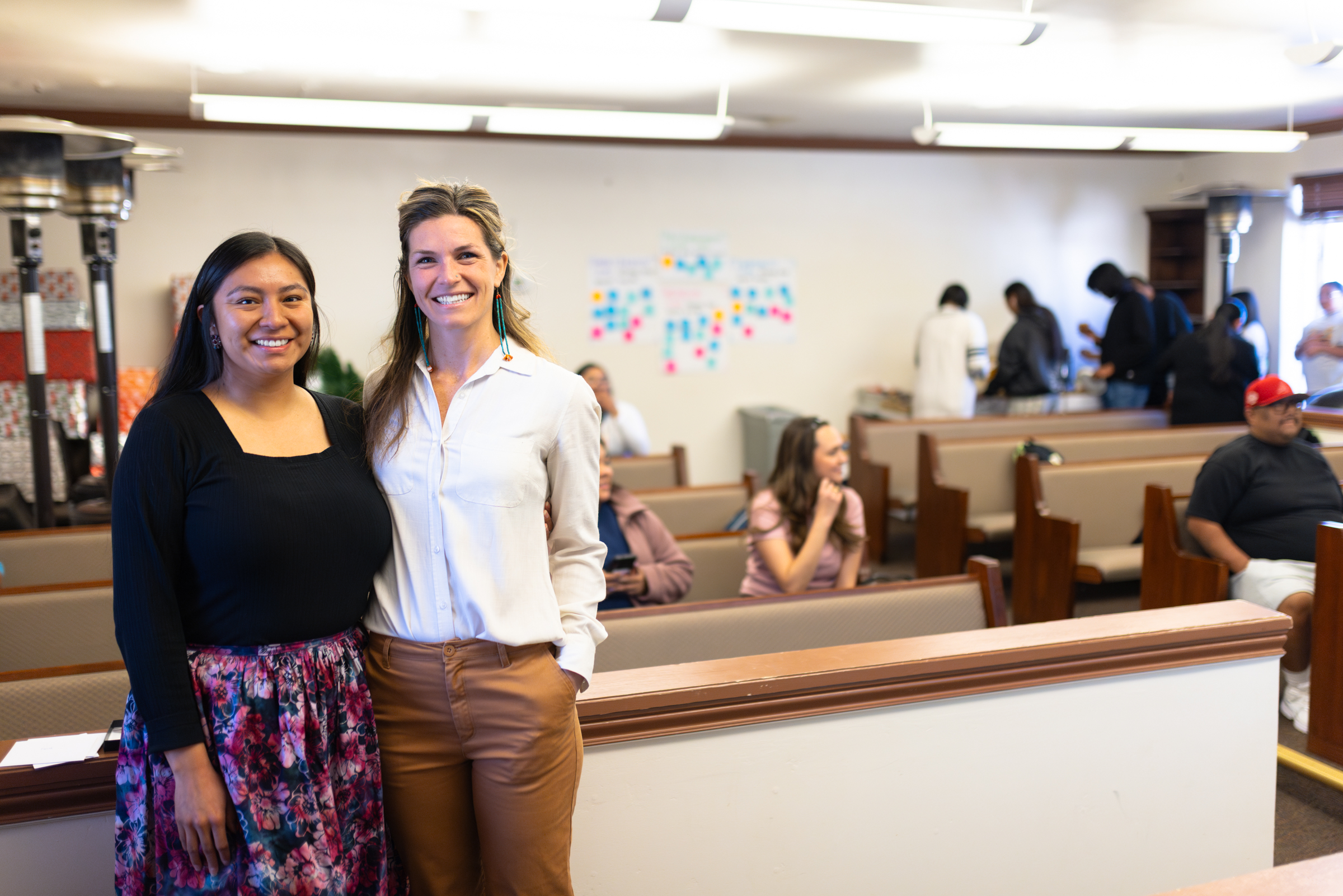 Marissa Tutt and Kelly McCue Nation smile in the front of a classroom of students