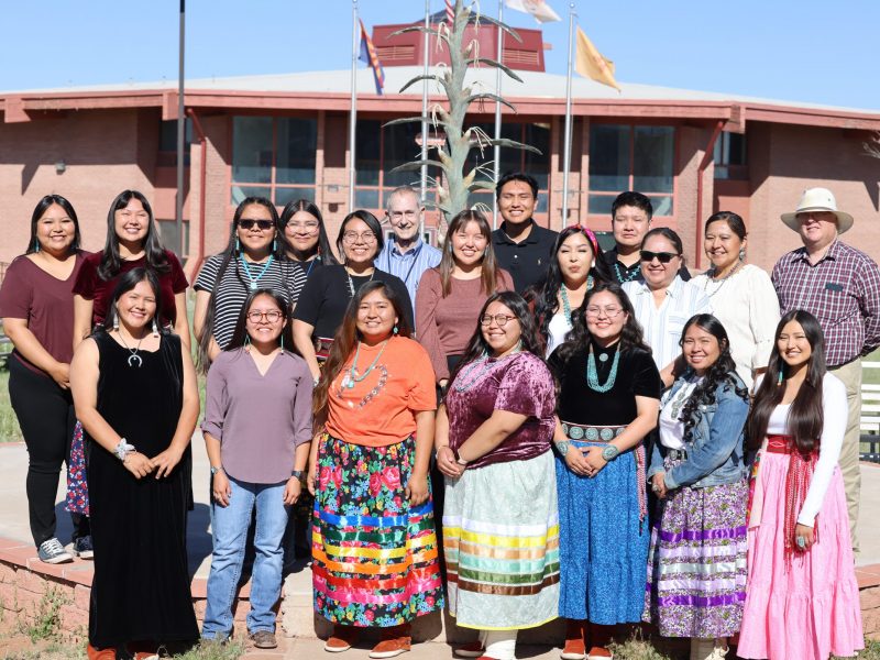 Students standing in rows in front of a Diné College school building