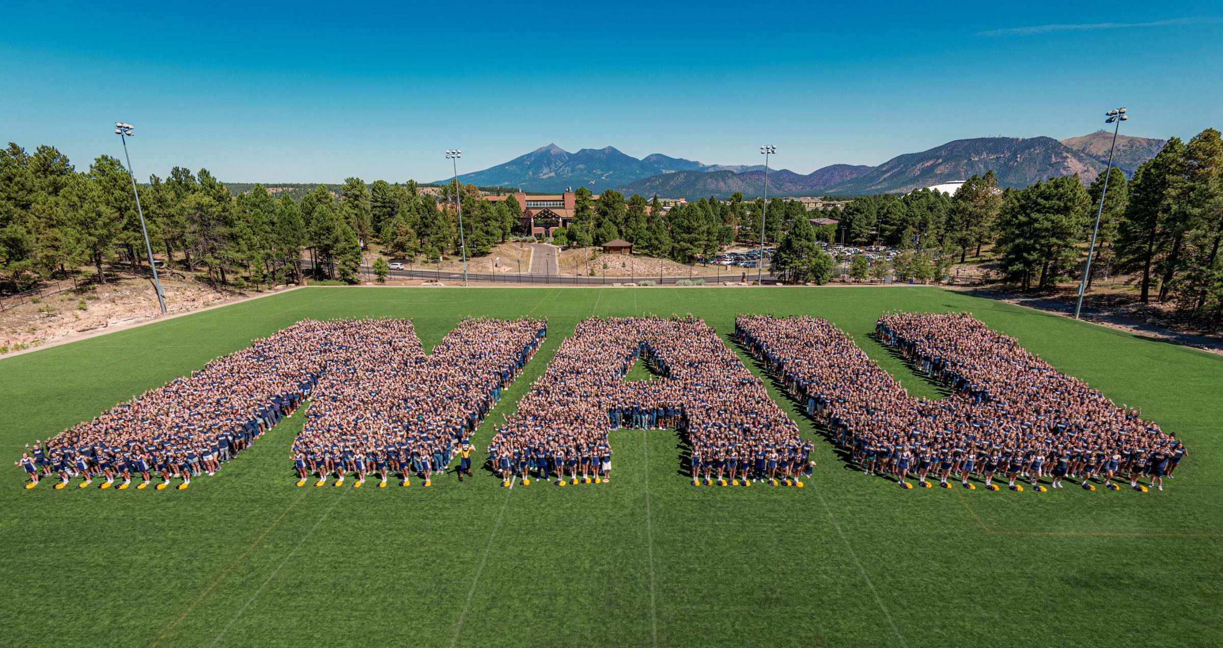 NAU students standing to form the letters N A and U
