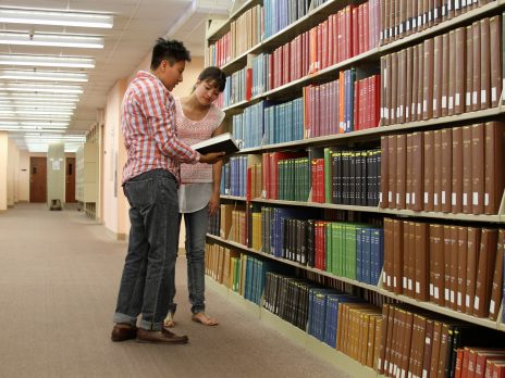 librarian with student in book stacks