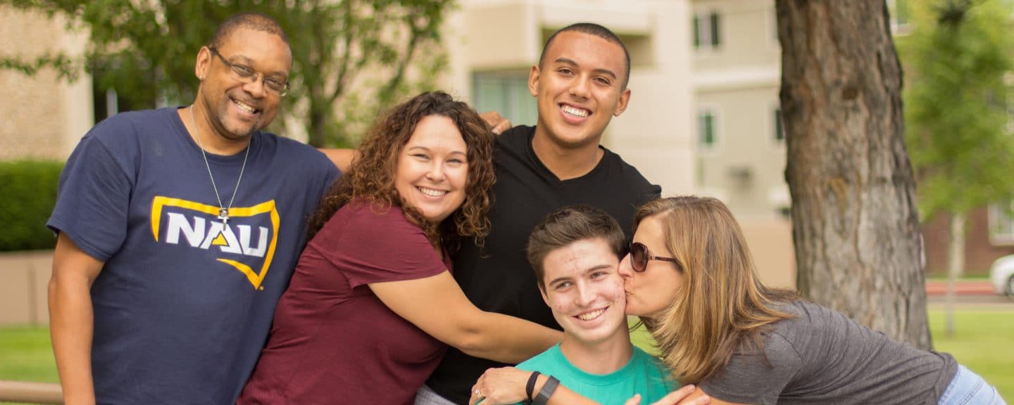 Diverse family group hugging during move in day