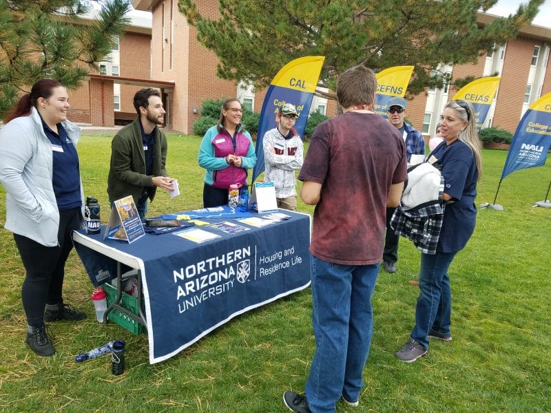 The Housing and Residence table during family weekend with the residential college flags
