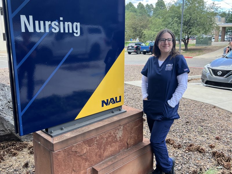 Nursing student posing with the N A U nursing sign.