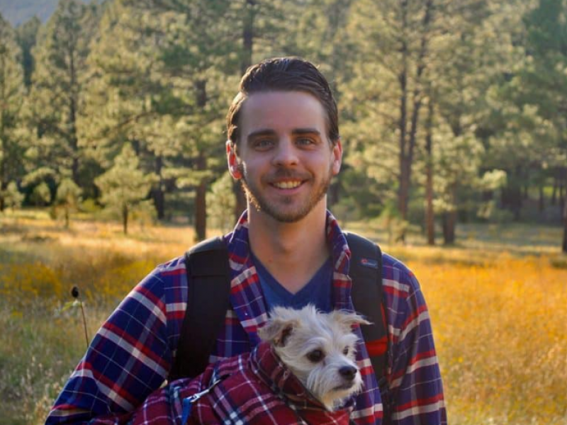Cody Rieffer, an N A U College of Nursing student,posing with a dog in his arm