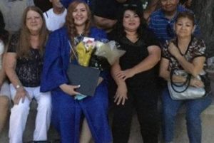 Jennifer in graduation regalia, smiling at the camera with four women also smiling at camera