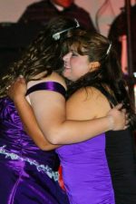 Two individuals hugging each other in nice dresses