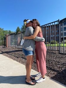Leilei embracing a woman, smiling and facing the camera