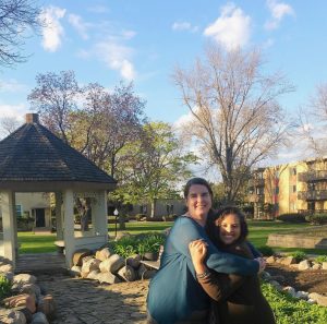 Katherine hugging a woman outside, smiling at the camera