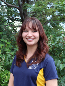 Lorissa smiling at camera in NAU polo