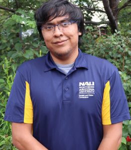 Milford smiling at camera in NAU polo