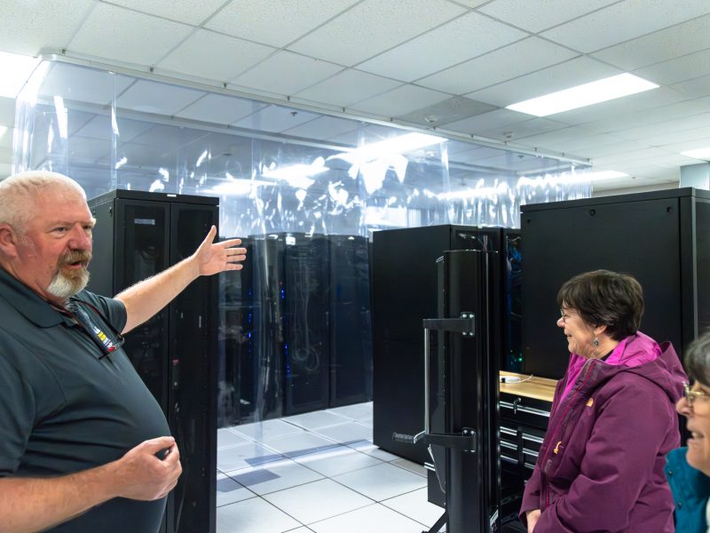 Brett West indicates the hot-cold containment barriers in the server room to Julie Baldwin and Cathy Propper