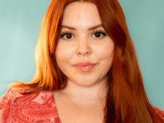 A headshot of Alex Olin who has red hair and is against a blue background 