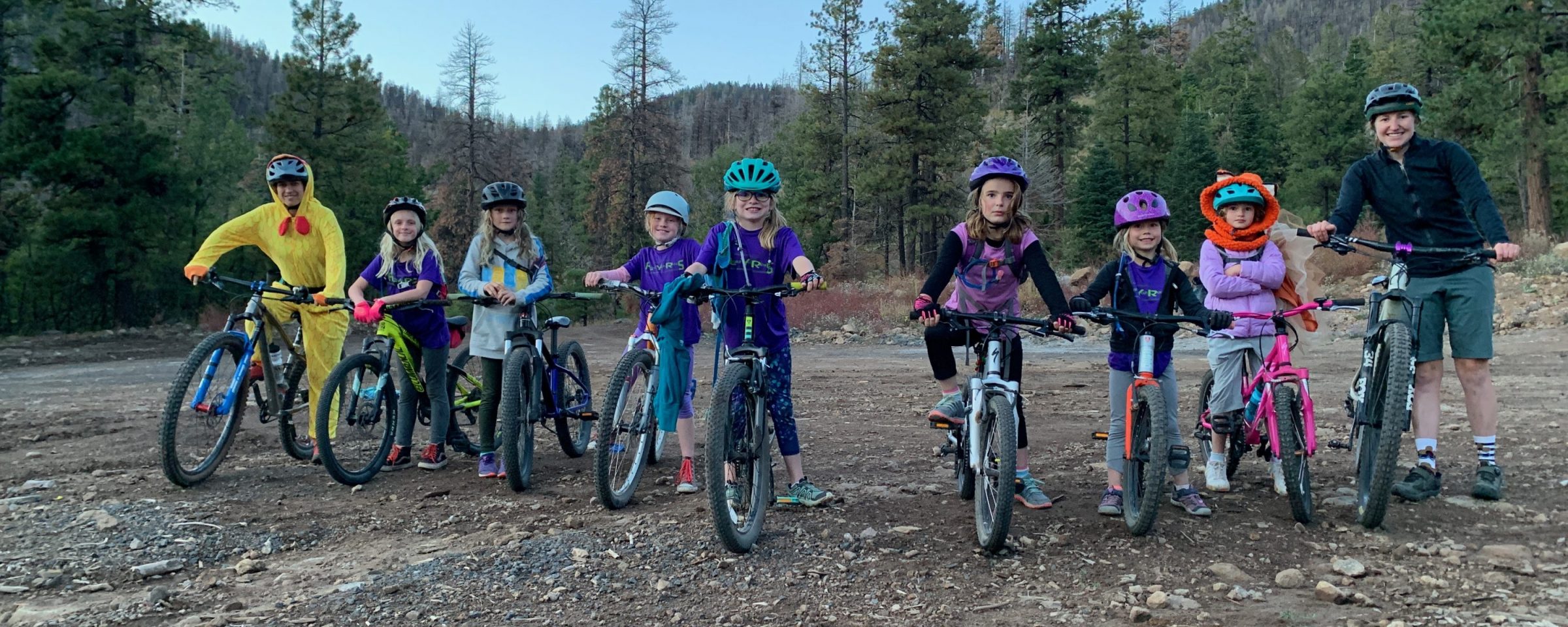 A group of FLYERS mountain biking kids standing on their bikes.
