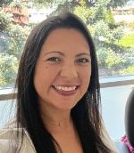 An image of a woman with brown hair, smiling