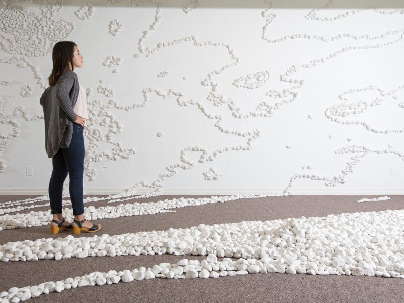 Woman standing amongst art installation 