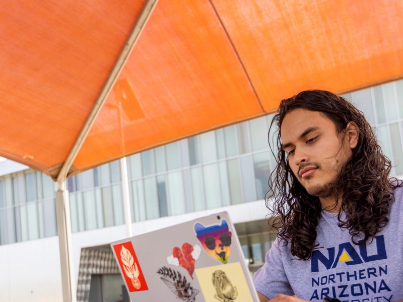Student, Eduardo Moreno works outside at the N A U–Yuma campus.
