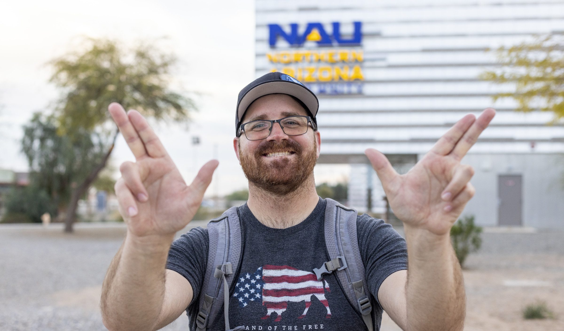 N A U–Yuma student holding up hands in jack symbol.