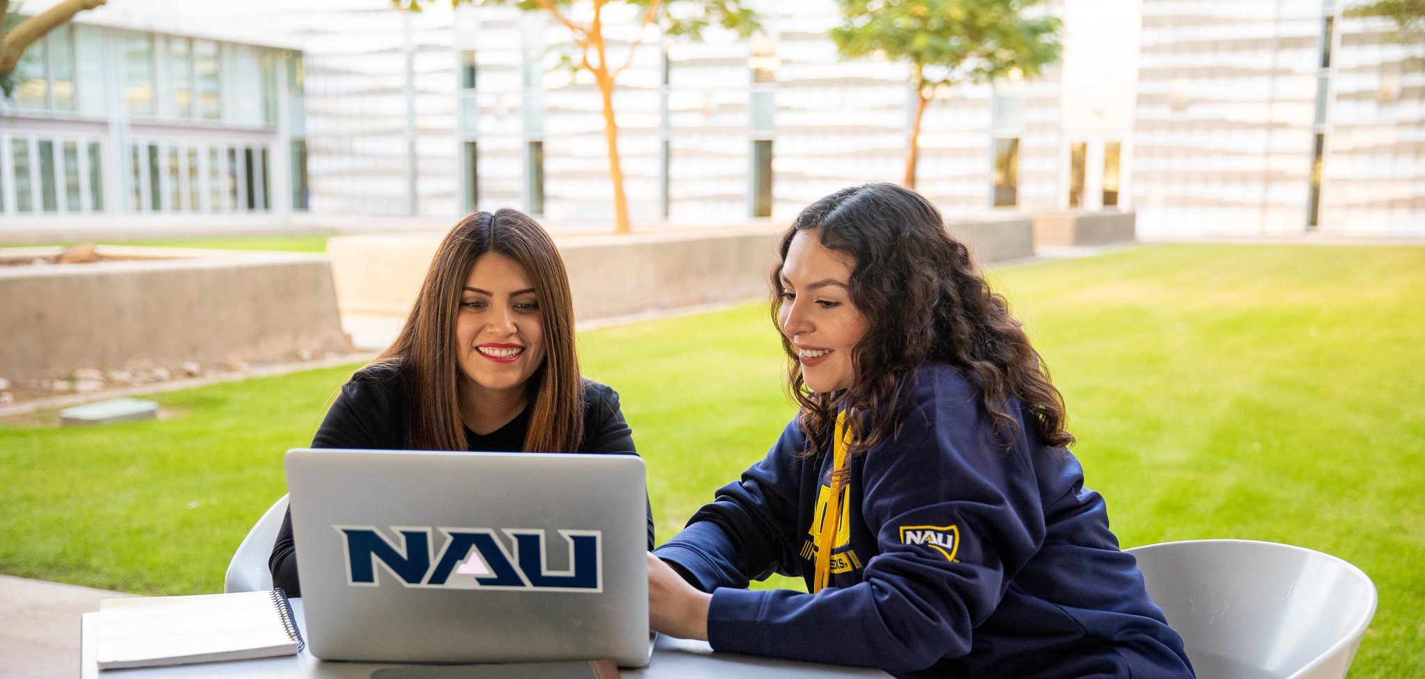 N A U–Yuma students outside working on Laptop.