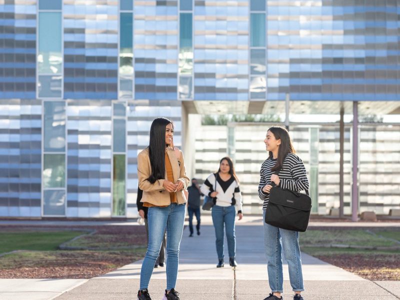 Students chatting outside of a building on the N A U–Yuma campus.