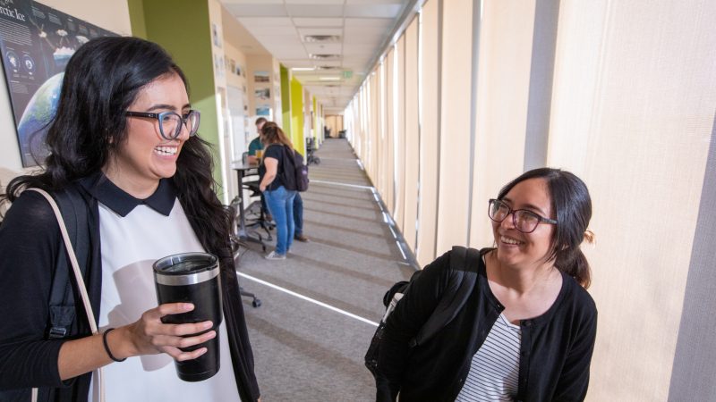 Two students sitting outside at N A U–Yuma campus.