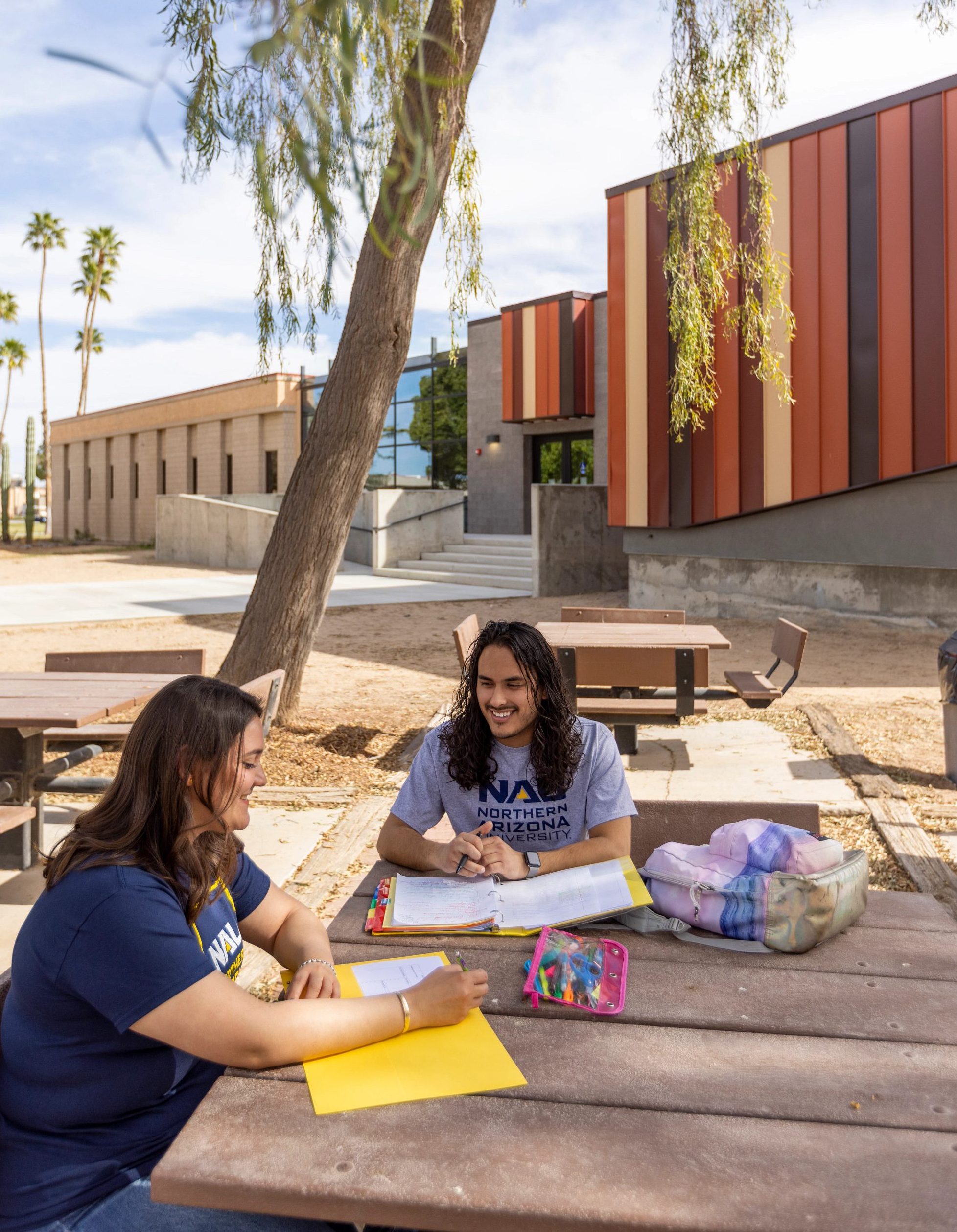 Two N A U–Yuma students sitting outside.