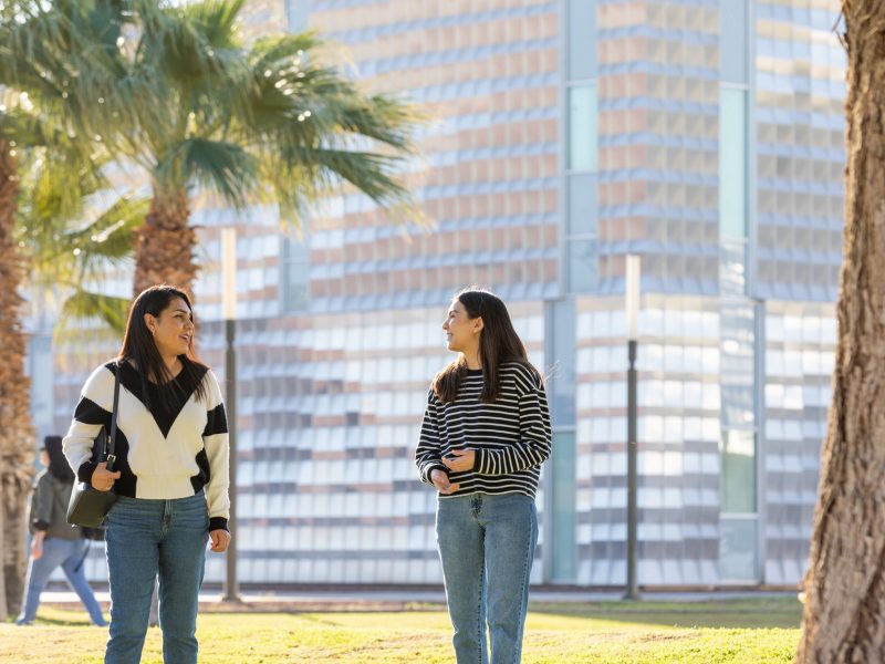 N A U–Yuma students talking outside on campus.