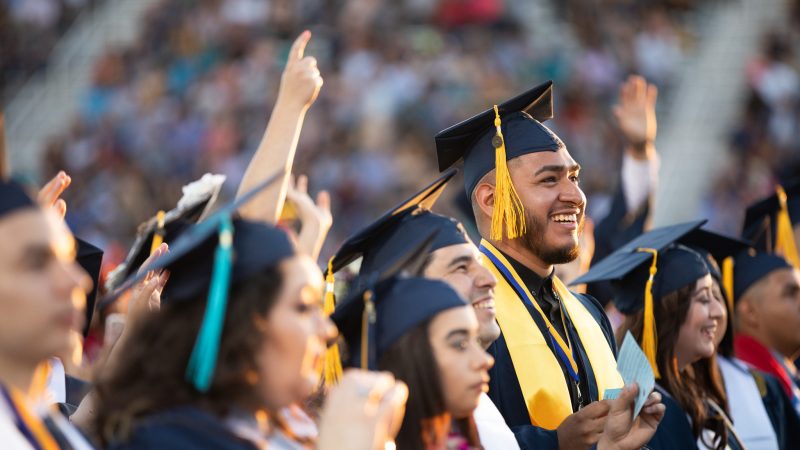 Students smile at N A U–Yuma commencement.